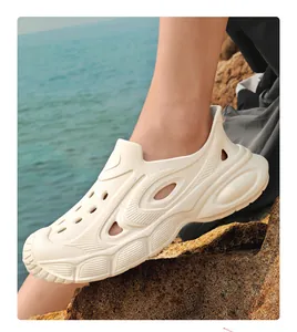 Close-up of cream breathable men's garden shoes on rocky shore with blue sea background
