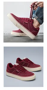 Detailed macro view of maroon men's canvas sneakers with white stitching and durable sole.