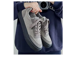 Close-up view of grey low-top men's canvas sneakers featuring thick black soles
