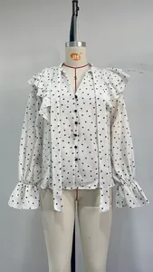 Close-up detail of white ruffle blouse with black heart polka dots and elegant tie-neck