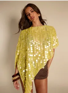 Nahaufnahme eines gelben Pailletten-Panchos mit unregelmäßigem Saum und Stricktextur