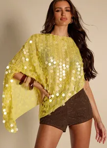 Detailansicht des gelben Pailletten-Ponchos mit Lochmuster und unregelmäßigem Saum.