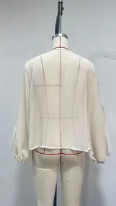 Back view detail of a white chiffon blouse with elegant ruffle bell sleeves on a dress form.