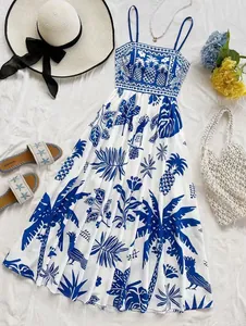 Flat lay of blue and white tropical print summer vacation dress with beach accessories