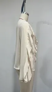 Detail of white chiffon blouse with elegant ruffles and flared cuffs on a mannequin