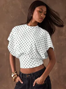 Detailed view of white retro polka dot blouse with batwing sleeves and cinched waist