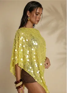 Detailansicht des gelben Pailletten-Ponchos mit Lochmuster und asymmetrischem Saum