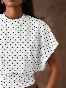 Close-up detail of a white French retro blouse with black polka dots and batwing sleeves