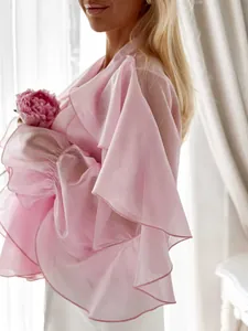 Close-up of pink chiffon blouse featuring elegant ruffled bell sleeves and soft texture.