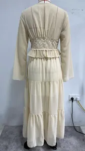 Detail eines beige Chiffon-Maxikleides im französischen Stil mit Spitzen-Taille und Rüschen.