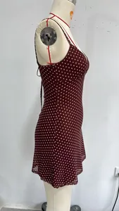 Detailed side view of a wine red polka dot sleeveless slim fit mini dress on a mannequin.