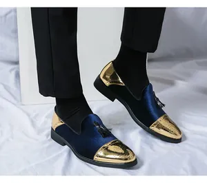 Gros plan de mocassins pour hommes en velours bleu et métal doré avec glands