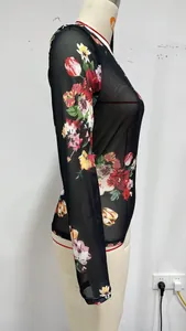 Detailed side view of a black floral mesh long-sleeve top on a white mannequin