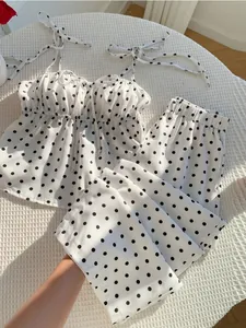 Detailansicht eines weißen zweiteiligen Punktesets mit Camisole-Top und langer Hose.