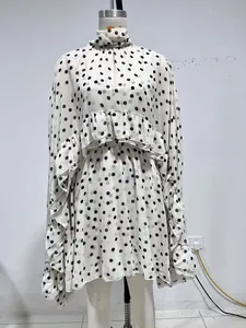 Detailweergave van een witte chiffon jurk met zwarte stippen en elegante ruches set