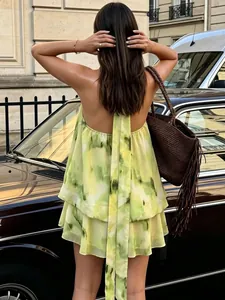 Vue de dos d'une robe courte chic tie-dye verte dos nu à volants avec longs liens.