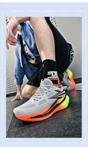Detailansicht grauer Laufschuhe mit leuchtend orangefarbenen und neongrünen Verläufen