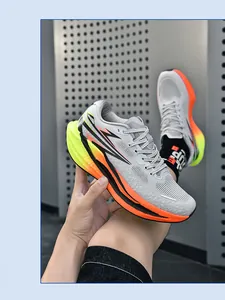 Detaillierte Seitenansicht grauer Laufschuhe mit leuchtend orange-gelber Verlaufssohle
