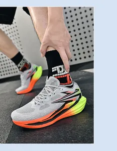 Detaillierte Seitenansicht modischer grauer und orangefarbener Laufschuhe mit Farbverlauf am Fuß