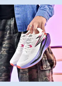 Nahaufnahme von weißen Schnür-Laufschuhen mit violetten und orangefarbenen Akzenten