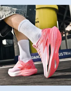Makroansicht von pinkfarbenen, atmungsaktiven Mesh-Laufschuhen mit dicker Dämpfungssohle.