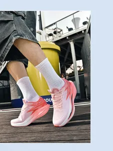 Seitenprofil von rosa-orangen Sportschuhen auf einem Holzsteg im Freien.