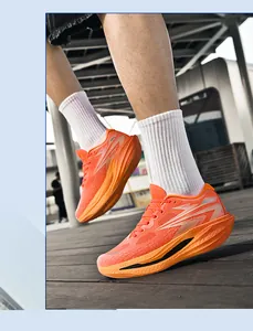 Vibrant leuchtend orangefarbene Laufschuhe mit Blitzmuster an den Füßen im Freien getragen