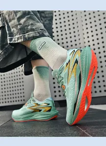 Detailansicht stilvoller mintgrüner Laufschuhe mit leuchtend orangefarbenen Sohlen.