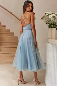 Detail view of an elegant light blue tulle midi dress with cross-back spaghetti straps.