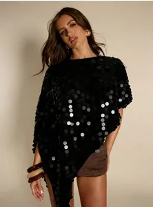 Detailaufnahme eines schimmernden schwarzen Pailletten-Ponchos mit unregelmäßigem Saum