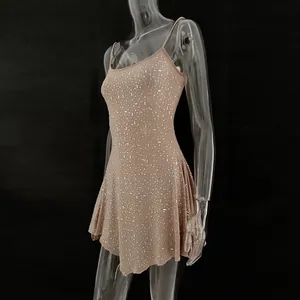 Close-up of nude mini dress featuring shimmering rhinestones and semi-sheer fabric