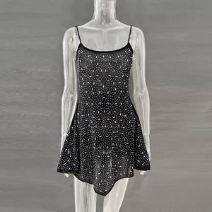 Detailed shot of a black sheer party mini dress decorated with sparkling rhinestones.