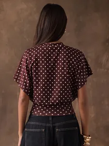 Back view of retro burgundy polka dot blouse with batwing sleeves and cinched waist