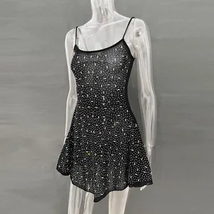 Detailed view of a black sheer mesh mini dress with shimmering rhinestone patterns.
