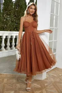 Elegant rust brown spaghetti strap midi dress with mesh tulle overlay in outdoor setting