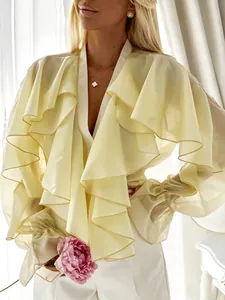 Detailed macro view of yellow ruffle chiffon blouse with elegant trumpet cuffs and V-neckline