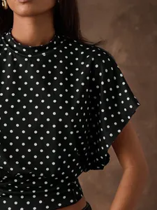 Close-up detail of retro black and white polka dot batwing sleeve cropped top