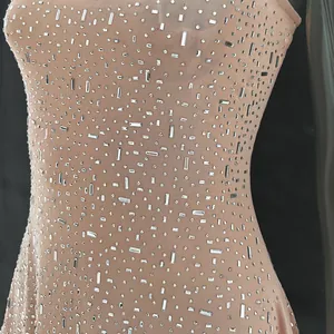 Close-up detail of silver rhinestones on semi-transparent nude mesh party dress fabric