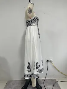 Seitenprofil eines weißen Boho-Maxikleides mit schwarzen Blumendrucken auf einer Schneiderpuppe