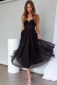 Close-up of elegant black corset tulle dress with flowing pleated skirt for summer parties