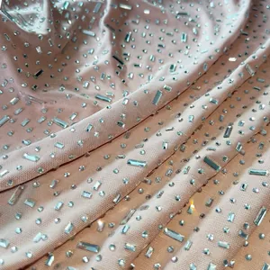 Detailed view of sheer nude mesh fabric adorned with sparkling crystal rhinestones.