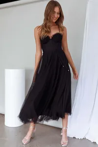Full view of an elegant black tulle midi dress with a corset-style bodice on a model