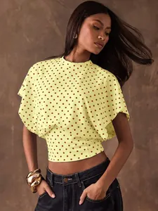 Model wearing a French vintage yellow polka dot crop top with batwing sleeves and slim fit