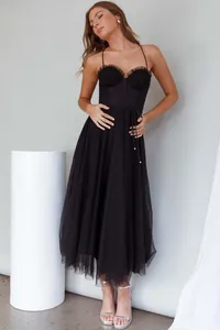 Detail view of an elegant black spaghetti strap dress with ruffled bustier and tulle skirt