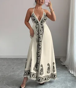 Detailansicht eines weißen Neckholder-Maxikleids mit schwarzem Boho-Blumendrucken