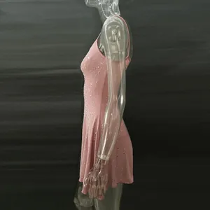 Side view of a pink rhinestone camisole mini dress on a clear mannequin.