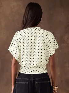 Back view of a French retro polka dot blouse with batwing sleeves and cinched waist