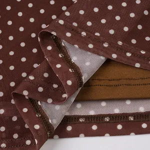Macro view showing the fine mesh texture and white polka dot pattern of the dress