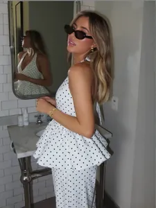 Elegante tweedelige set met haltertop met stippen en wijde pijpen broek voor dames