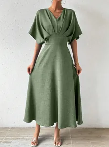 Close-up view of a green V-neck midi dress with waist-tightening detail and batwing sleeves